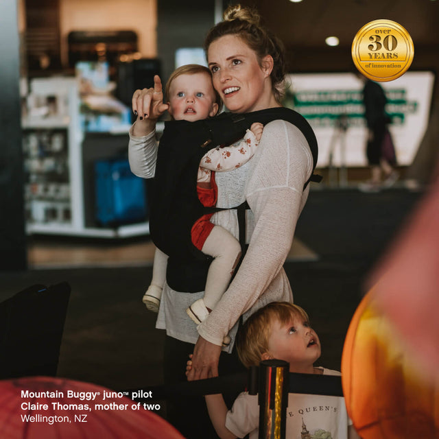 una madre lleva a su hijo en una mochila portabebés juno™ en posición mirando a los padres - Mountain Buggy juno™  piloto Claire Thomas, madre de dos hijos, Wellington, Nueva Zelanda