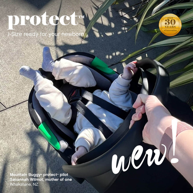 bebé sentado en la cápsula de la silla de auto siendo transportado por Savannah Wilmot utilizando el asa de la silla de auto infantil mountain buggy protect™ - Whakatane Nueva Zelanda.